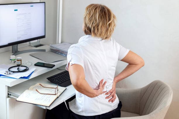 Profesional en Madrid sufriendo de dolor de espalda urgente necesita servicio de fisioterapia a domicilio.